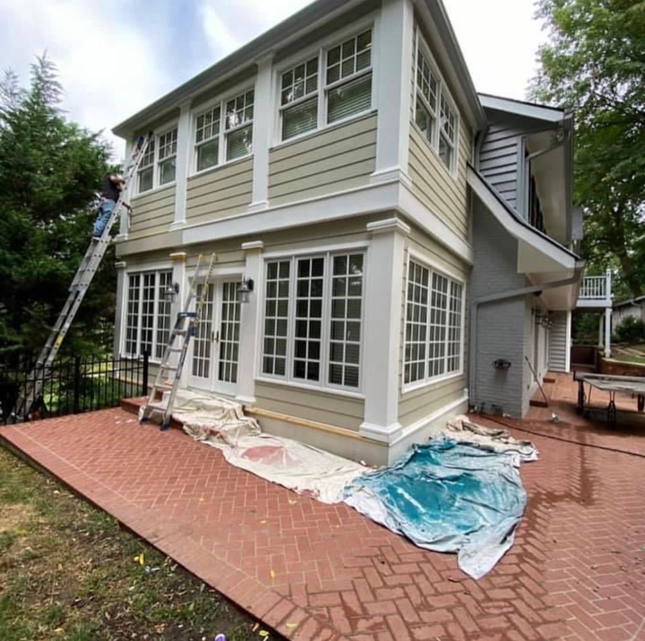 Colourland Painting team repainting a weatherboard house exterior in Wollongong with proper prep and drop sheets