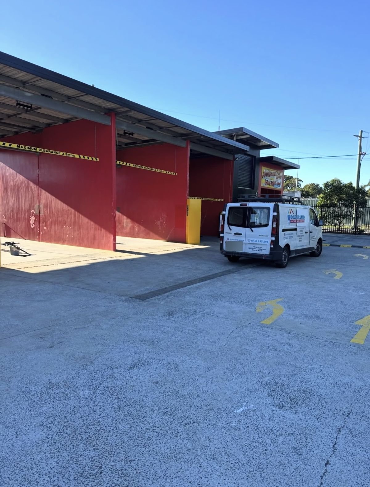 Faded, peeling red wash-bay walls at an Illawarra car wash before Colourland Painting repainted them
