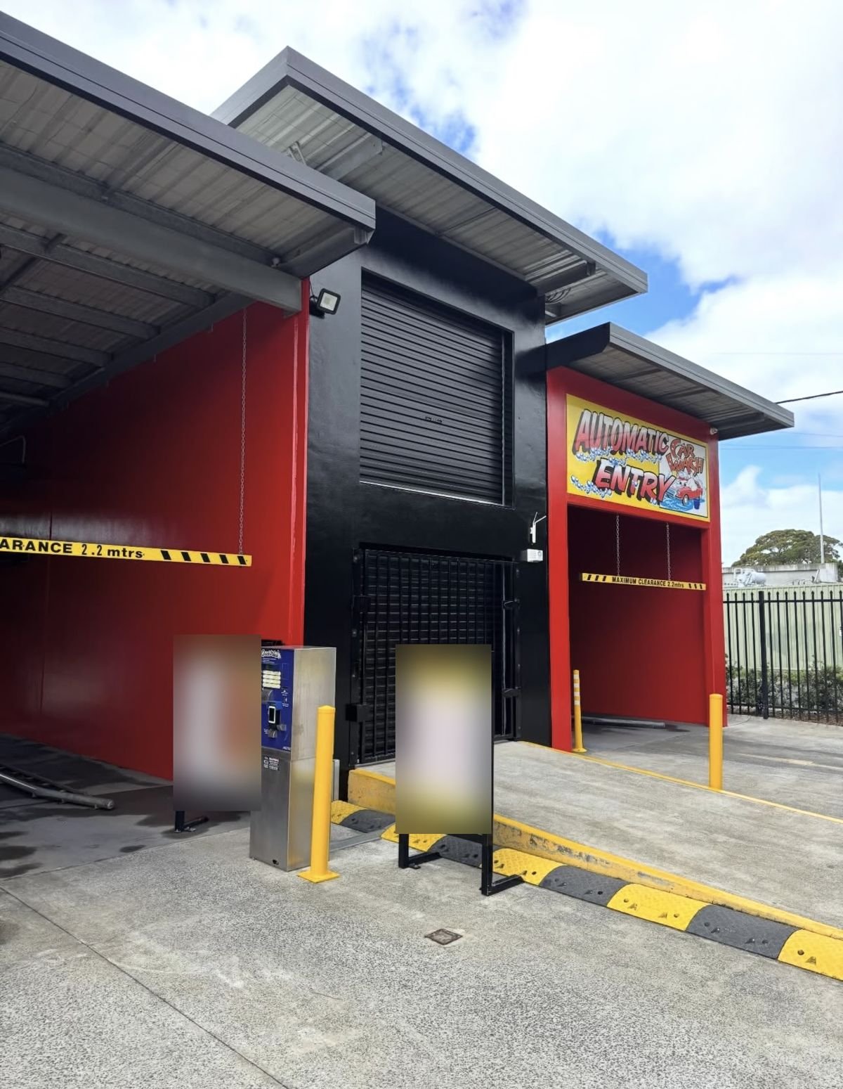 Repainted car wash entry in red and black with refreshed safety yellow, commercial painters Wollongong